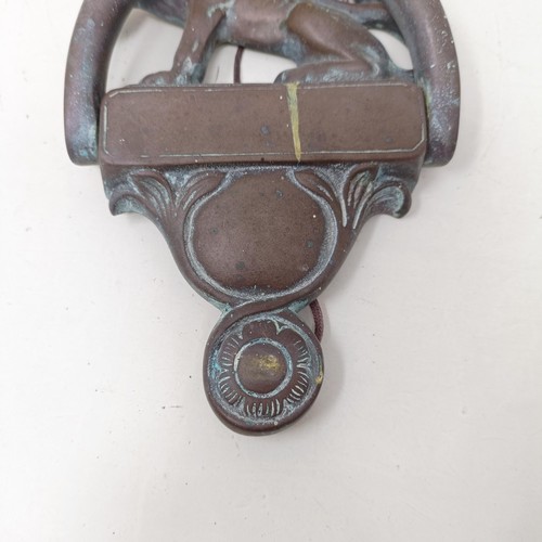 1292 - A bronze door knocker, with a lion finial, 25 cm high