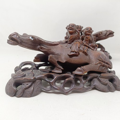 1325 - A pair of Chinese carved hardwood buffaloes, on stands, 24 cm wide