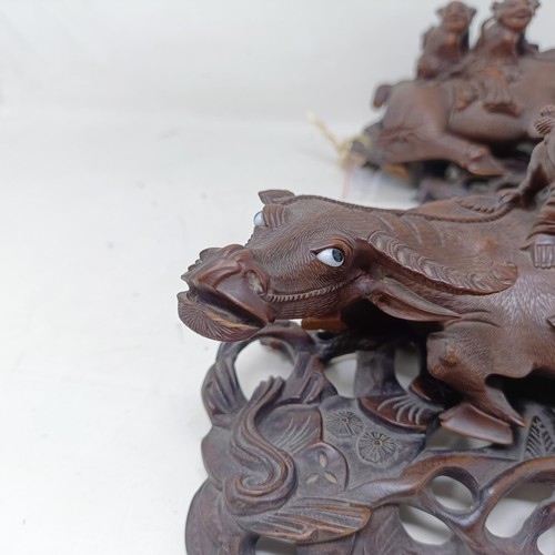 1325 - A pair of Chinese carved hardwood buffaloes, on stands, 24 cm wide