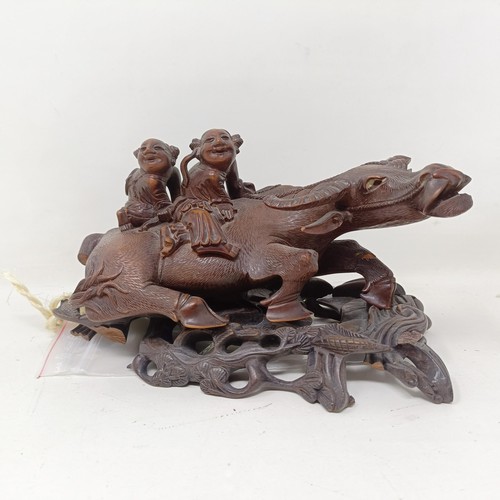 1325 - A pair of Chinese carved hardwood buffaloes, on stands, 24 cm wide