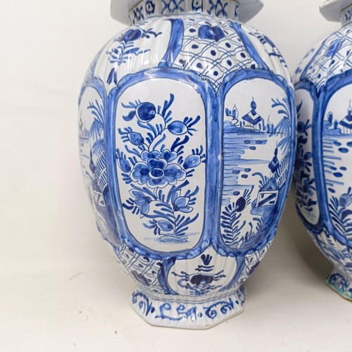 1323 - A pair of Delft blue and white vases and covers, decorated flowers, 34 cm high (2)