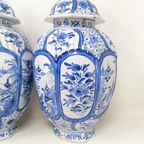 1323 - A pair of Delft blue and white vases and covers, decorated flowers, 34 cm high (2)