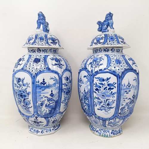 1323 - A pair of Delft blue and white vases and covers, decorated flowers, 34 cm high (2)