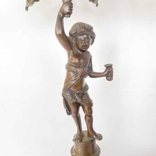 1309 - A pair of bronze figural five branch candelabra, on shaped bases and lion paw feet, 66 cm high