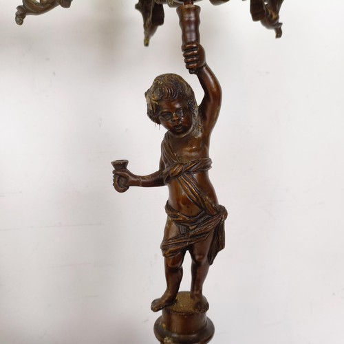 1309 - A pair of bronze figural five branch candelabra, on shaped bases and lion paw feet, 66 cm high