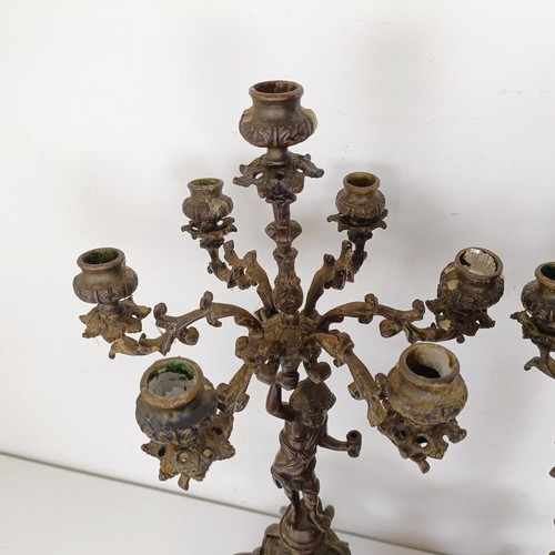 1309 - A pair of bronze figural five branch candelabra, on shaped bases and lion paw feet, 66 cm high