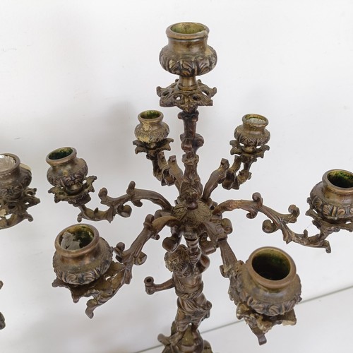 1309 - A pair of bronze figural five branch candelabra, on shaped bases and lion paw feet, 66 cm high