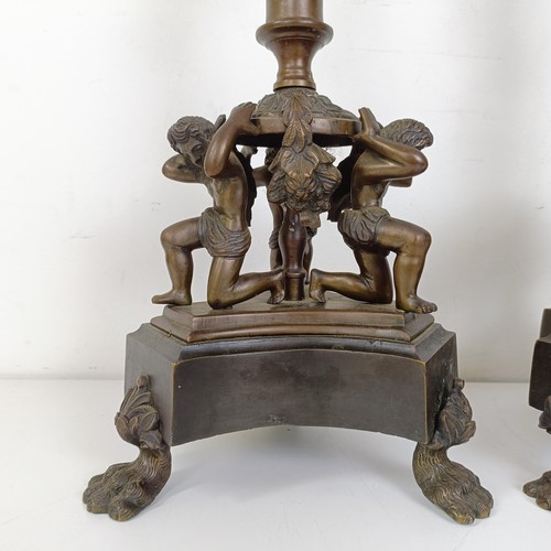 1309 - A pair of bronze figural five branch candelabra, on shaped bases and lion paw feet, 66 cm high