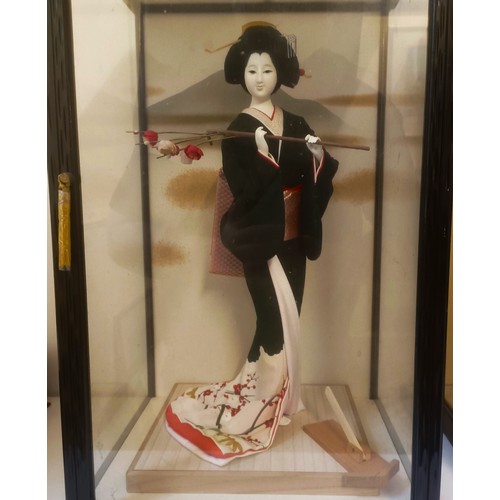 1226 - A Japanese doll, in traditional dress, in a glazed case, 54 cm high, and two others similar (3)