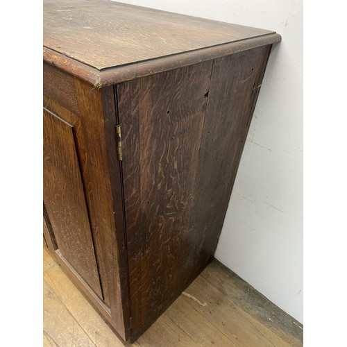 1405 - An oak estate cabinet, the two cupboard doors to reveal two slides and three drawers, 123 cm wide