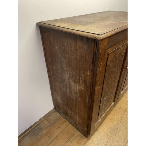 1405 - An oak estate cabinet, the two cupboard doors to reveal two slides and three drawers, 123 cm wide