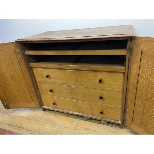 1405 - An oak estate cabinet, the two cupboard doors to reveal two slides and three drawers, 123 cm wide