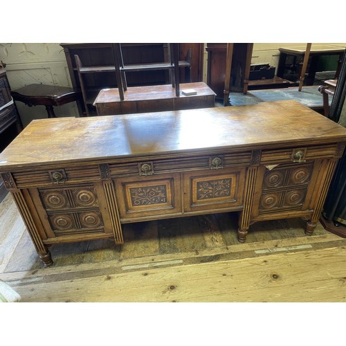 463 - An early 20th century Aesthetic style walnut sideboard, having three drawers, and four cupboard door... 