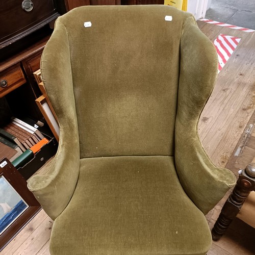 1374 - A George I wingback armchair, on walnut cabriole front legs and pad feet