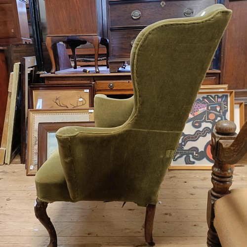 1374 - A George I wingback armchair, on walnut cabriole front legs and pad feet