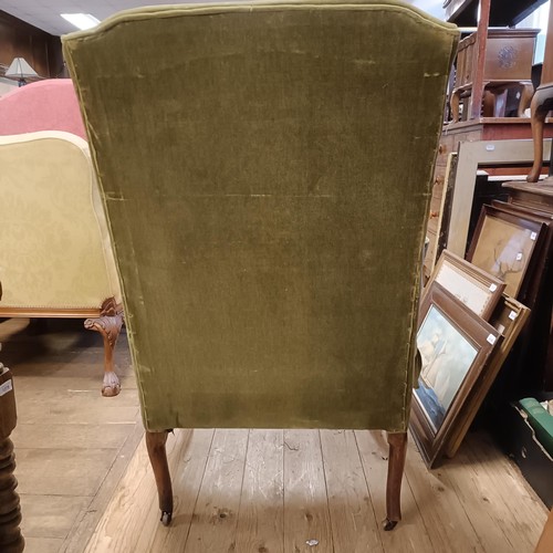 1374 - A George I wingback armchair, on walnut cabriole front legs and pad feet