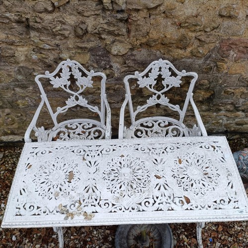 1491 - A painted metal garden table, 110 cm wide, and a pair of armchairs (3)