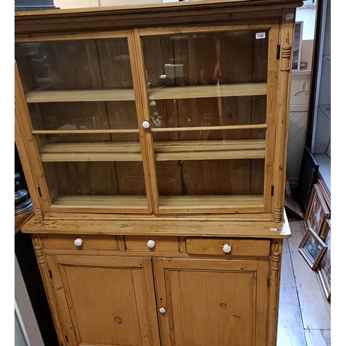 1398 - A pine dresser, the top having two glazed doors, on a base with three drawers and two cupboard doors... 