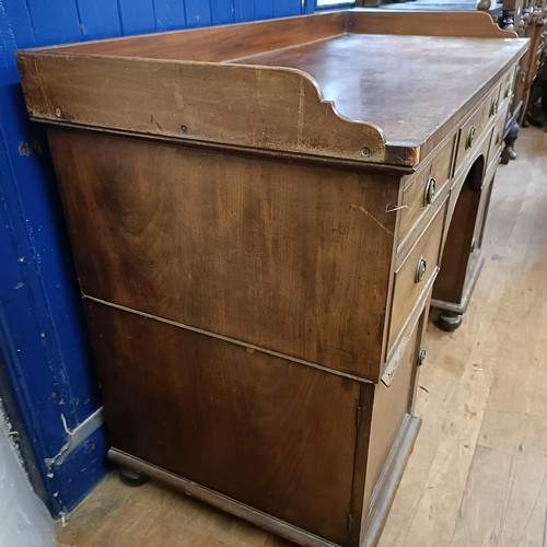 1387 - A Regency mahogany pedestal desk, the top having a raised back, with five drawers, on two squat pede... 