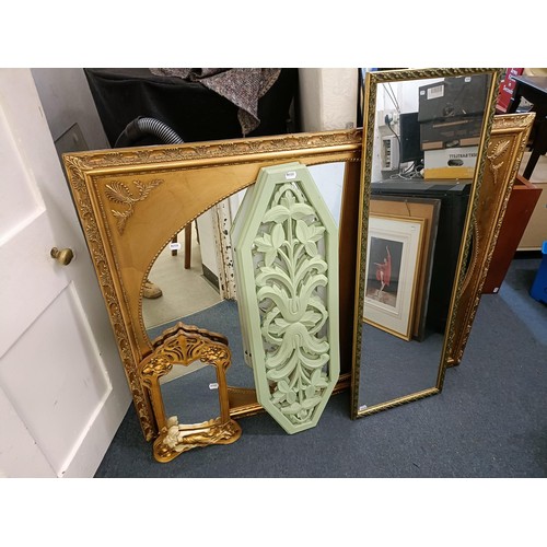 1537 - A gilt framed wall mirror, 110 x 137 cm, two other mirrors, and two painted panels with pierced deco... 