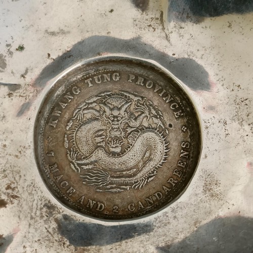 56 - A Chinese silver coloured metal dish, of shaped petal form, the base inset with a coin, 11.5 cm diam... 