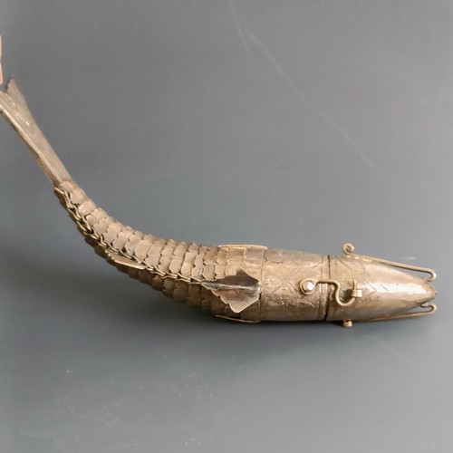 63 - An articulated silver coloured metal fish, with engraved decoration, 16.5 cm