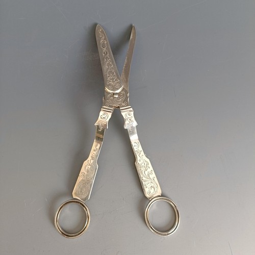 198 - A pair of Victorian silver grape scissors, with engraved decoration, crested, marks indistinct, 2.6 ... 