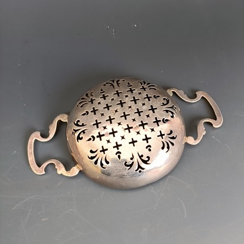 200 - An 18th century silver two handle lemon strainer, apparently unmarked, 15 cm wide