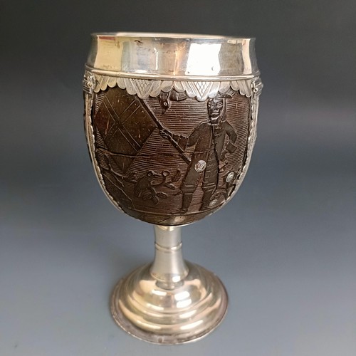 224 - A 17th/18th century silver mounted coconut cup, carved figures, 16.5 cm high