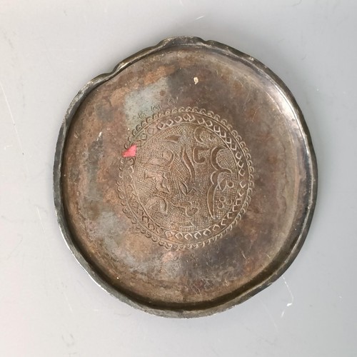 255 - An Iraqi silver coloured metal counter dish, with calligraphy to the centre, 7 cm diameter