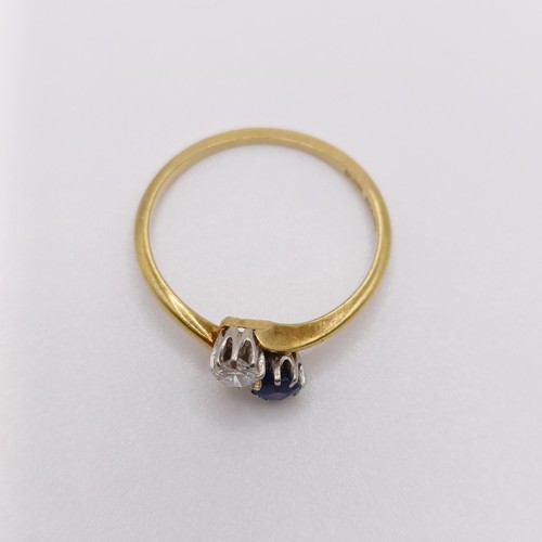 513 - An 18ct gold, diamond and sapphire crossover ring, ring size O