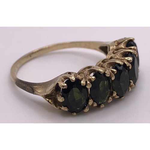 518 - A 9ct gold and green stone five stone ring, ring size L