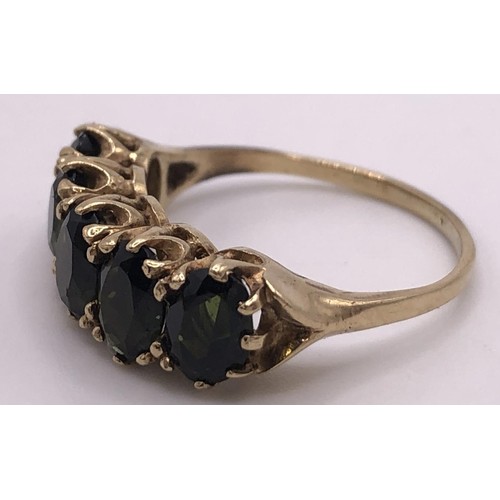 518 - A 9ct gold and green stone five stone ring, ring size L