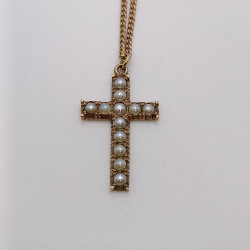 530 - An early 20th century yellow metal and cultured pearl cross pendant, on a yellow metal chain, in a v... 