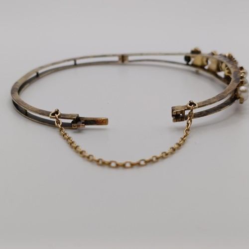 538 - A yellow metal and seed pearl floral bangle