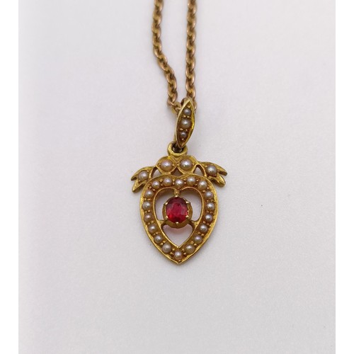 561 - A 15ct gold, seed pearl and red stone heart shaped pendant, on a 9ct gold chain