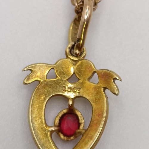 561 - A 15ct gold, seed pearl and red stone heart shaped pendant, on a 9ct gold chain