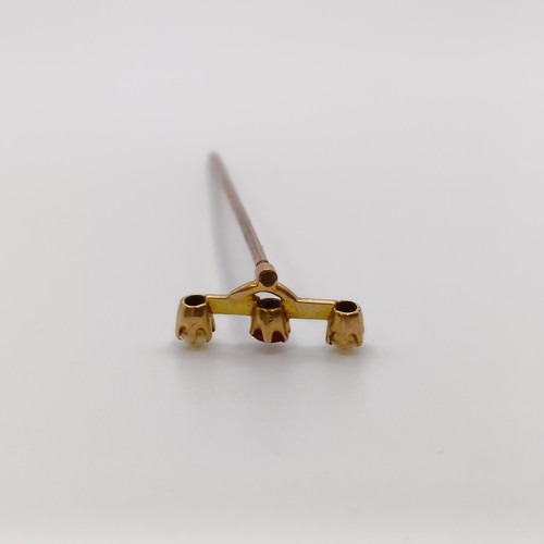 590 - A stick pin, inset with a red coloured stone and seed pearls