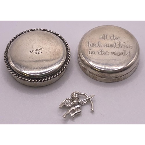 592 - A silver coloured metal pill box, and a small cherub charm (2)