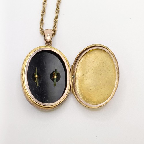 624 - A yellow coloured red metal, enamel and seed pearl oval locket, on a chain