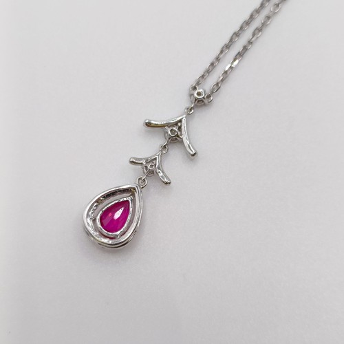 632 - An 18ct white gold, ruby and diamond pendant, on an 18ct gold chain