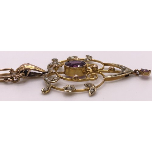 640 - An early 20th century, yellow metal, purple stone and seed pearl pendant, on a 9ct gold chain, all i... 