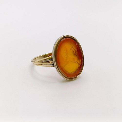 642 - An 18ct gold and carved carnelian ring, decorated a portrait, ring size G