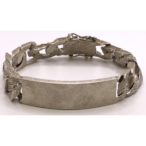 648 - A textured silver identity bracelet, 64.5 g