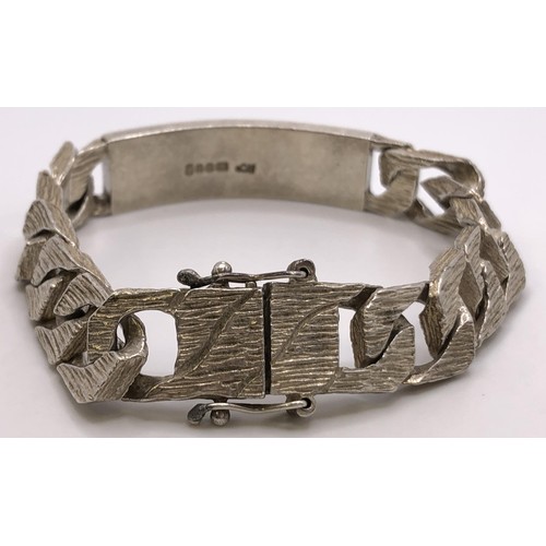 648 - A textured silver identity bracelet, 64.5 g