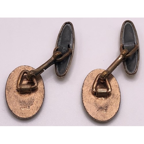 663 - A pair of gold plated and enamel oval cufflinks