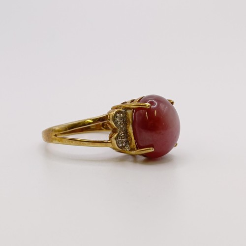 675 - A 9ct gold and cabochon cut star ruby ring, with diamond shoulders, ring size M