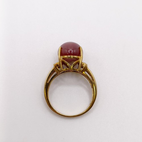 675 - A 9ct gold and cabochon cut star ruby ring, with diamond shoulders, ring size M