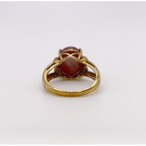 675 - A 9ct gold and cabochon cut star ruby ring, with diamond shoulders, ring size M