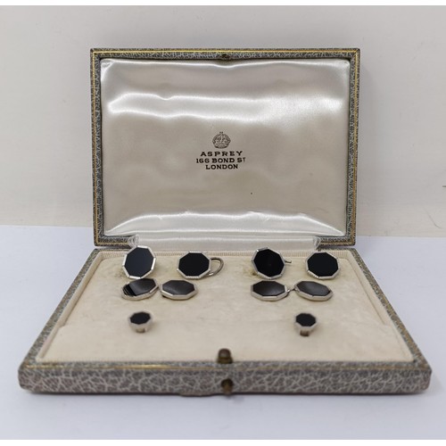 716 - An Asprey silver coloured metal and black enamel button set, cased